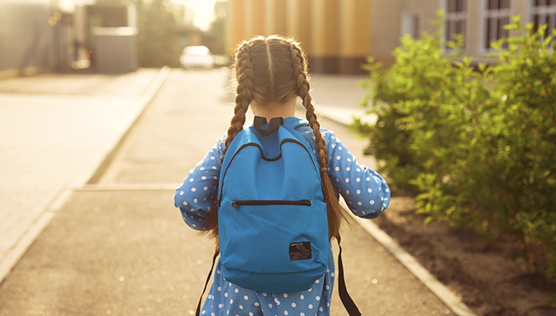 Girl with backpack walking to school