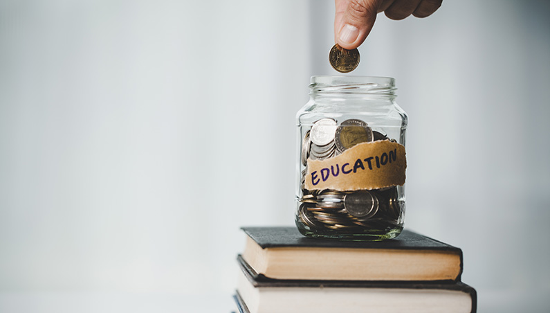 Saving coins in jar labelled education